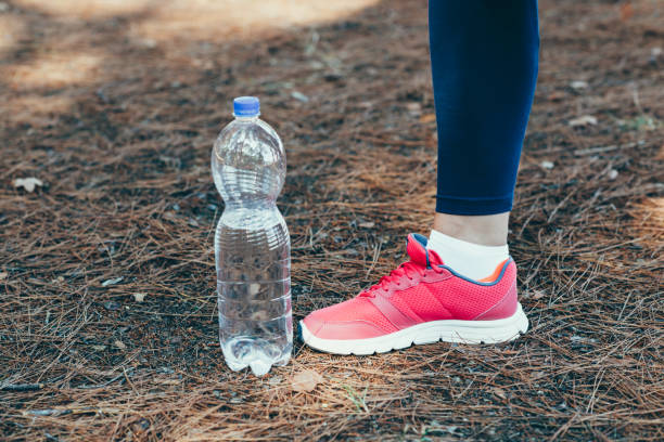 istock Woman drinking water after exercise in park. 843672944