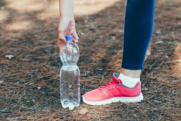 Woman drinking water after exercise in park. Summer vacation with health benefits. Woman drinking water after exercise in park. see through leggings stock pictures, royalty-free photos & images