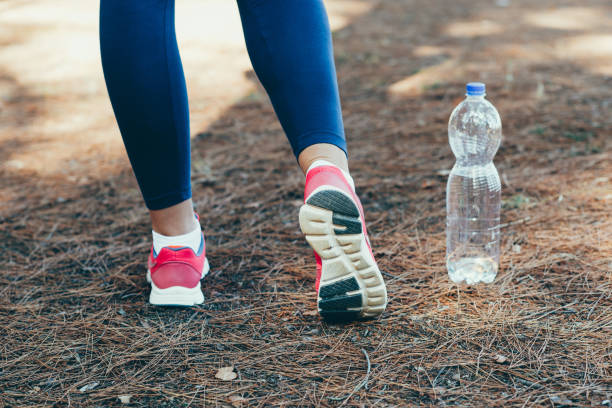 istock Woman drinking water after exercise in park. 843673180