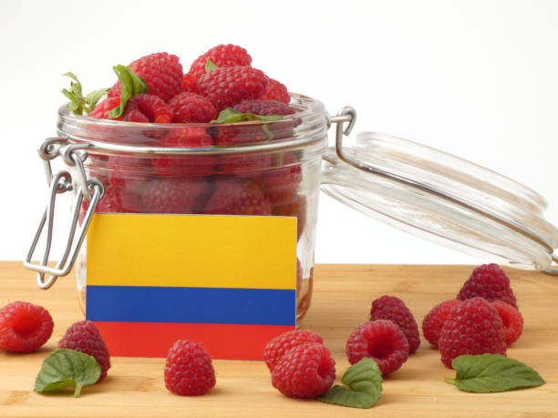 istock Colombian flag on a wooden panel with raspberries isolated on a white background 843673230