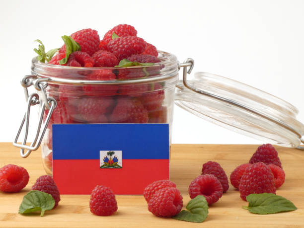 istock Haiti flag on a wooden panel with raspberries isolated on a white background 843673334