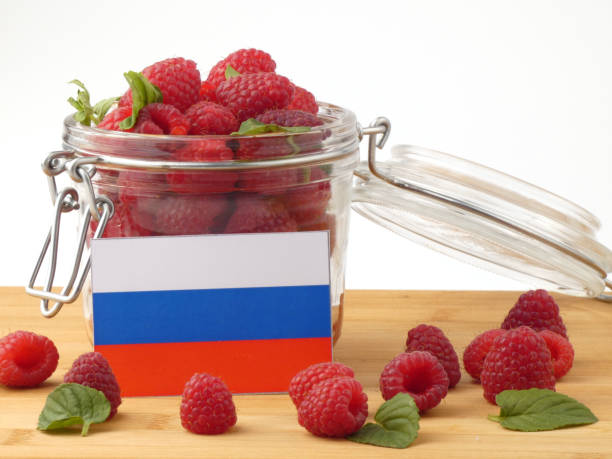 istock Russia flag on a wooden panel with raspberries isolated on a white background 843675758