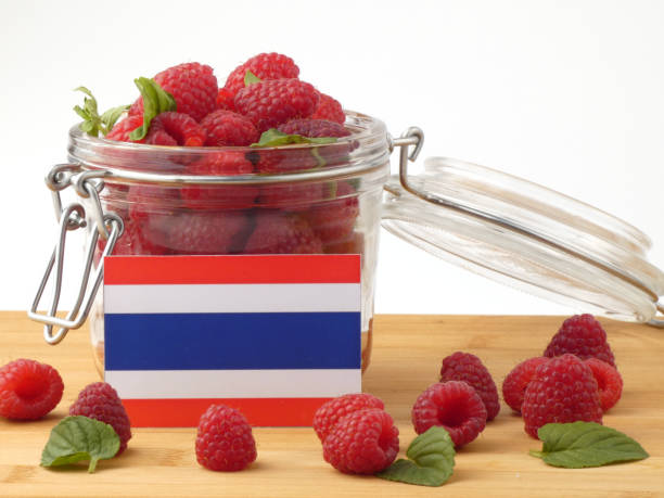 istock Thai flag on a wooden panel with raspberries isolated on a white background 843675950