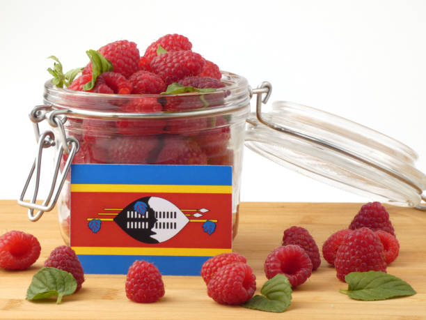 istock Swaziland flag on a wooden panel with raspberries isolated on a white background 843676150