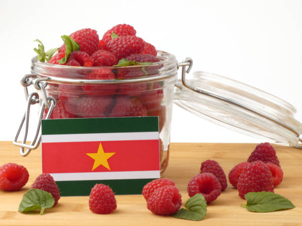 istock Suriname flag on a wooden panel with raspberries isolated on a white background 843676334