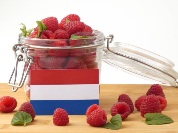 istock Dutch flag on a wooden panel with raspberries isolated on a white background 843678240