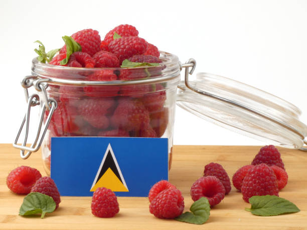 istock Saint Lucia flag on a wooden panel with raspberries isolated on a white background 843680878