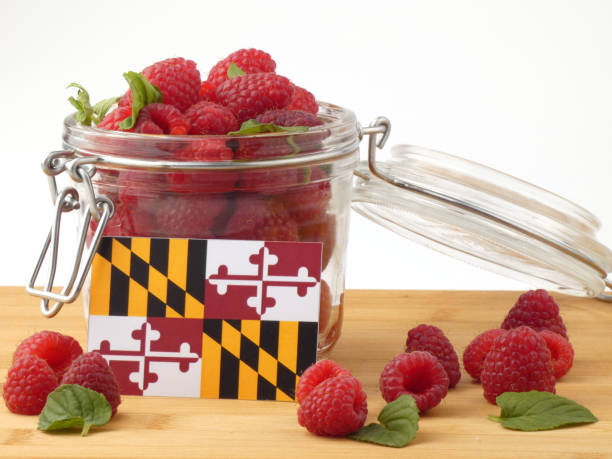 istock Maryland flag on a wooden panel with raspberries isolated on a white background 843686872