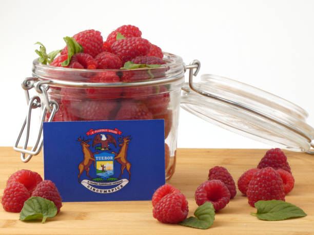 istock Michigan flag on a wooden panel with raspberries isolated on a white background 843690300