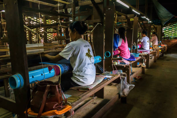 las mujeres tejen patrones con seda en camboya - garment factory fotografías e imágenes de stock