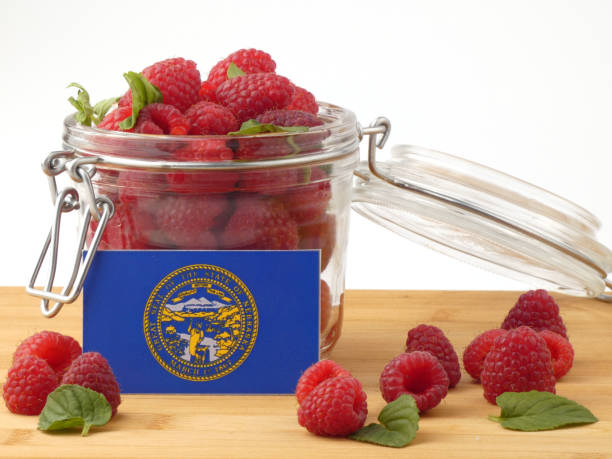 istock Nebraska flag on a wooden panel with raspberries isolated on a white background 843693612