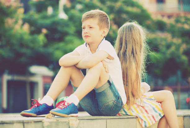 istock sad boy sitting back to friend outdoor 843697460