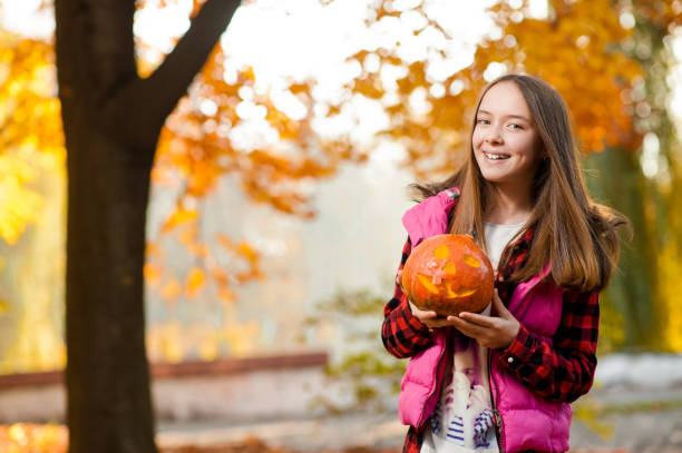 istock Young girl smiling joyfully with a pumpkin in her hands 843701010