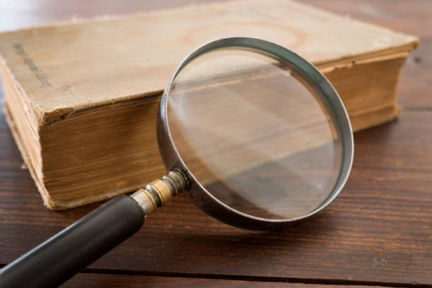 istock Old book and magnifying glass 843701560