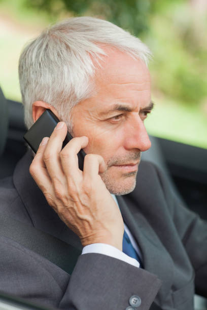 istock Serious businessman on the phone driving cabriolet 843702872