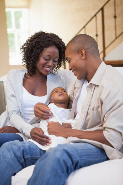 istock Happy parents spending time with baby on the couch 843703052
