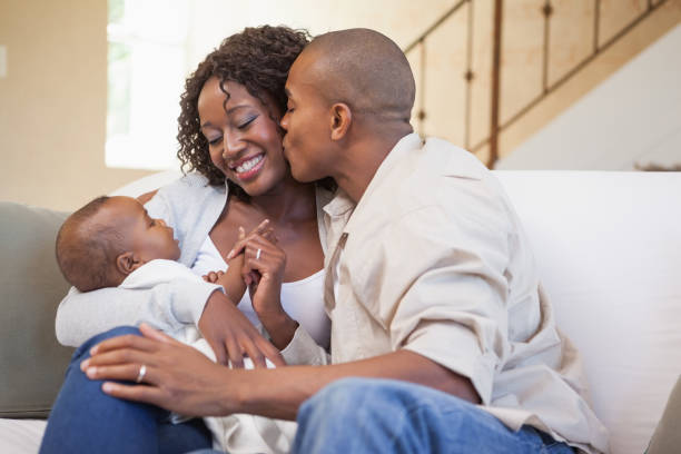 istock Happy parents spending time with baby on the couch 843703112