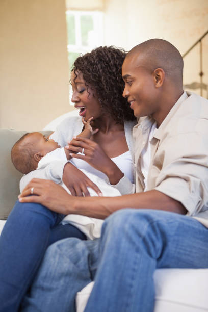 istock Happy parents spending time with baby on the couch 843703114