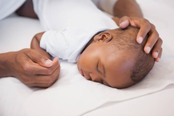 istock Baby boy sleeping peacefully on couch with father 843706310