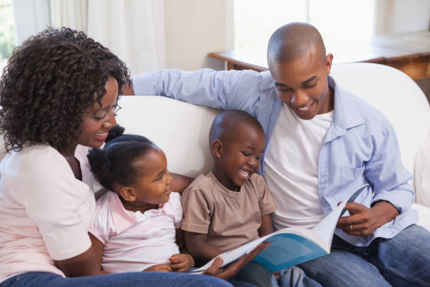 istock Happy family sitting on couch together reading book 843706846