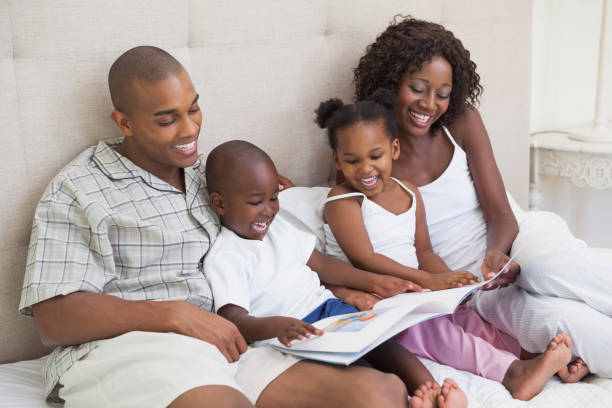 istock Happy family lying on bed reading book 843707138