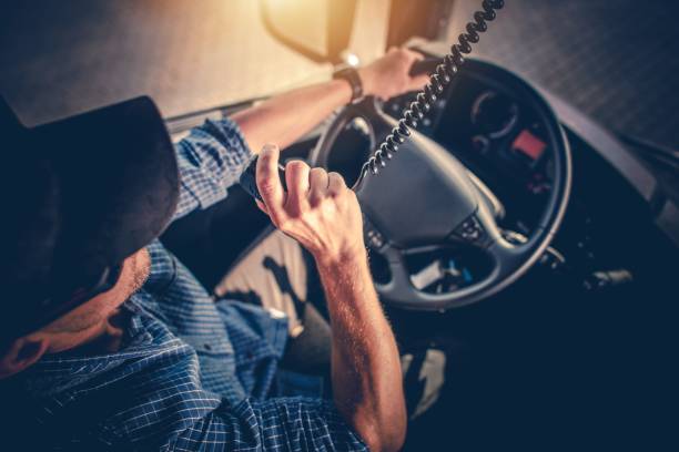Truck Driver CB Radio Talk Semi Truck Driver Making Conversation with Other Truck Drivers Through CB Radio. truck driver stock pictures, royalty-free photos & images