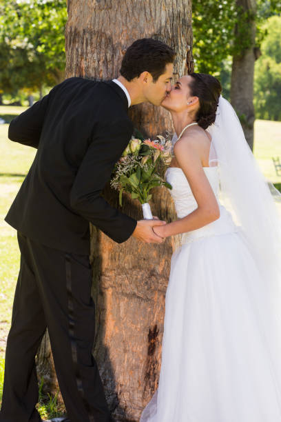 istock Romantic newlywed couple kissing in park 843717556