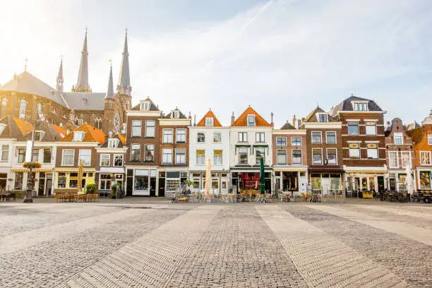 View on the beautiful buildings facades and church on the central square during the sunny morning in Delft city, Netherland