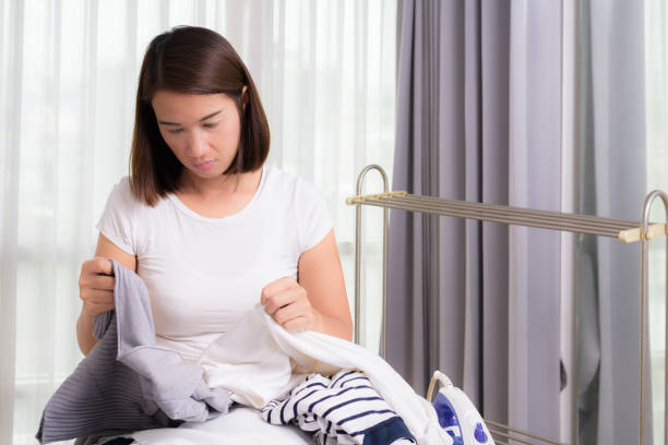 istock woman is leaning on the basin with laundry and looking at clothes on ironing board 843729574