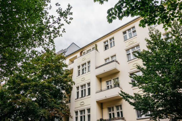 istock apartment house framed by green trees 843736528