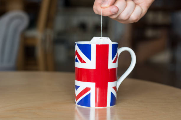 istock Putting a teabag in a mug with a Great Britain flag on it close up with blurry background 843737404
