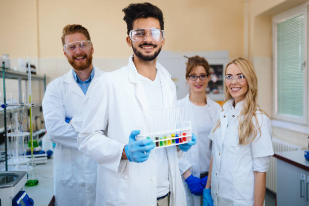 카메라에 포즈를 취하는 젊은 성공적인 과학자의 그룹 - healthcare and medicine smiling group of people lab coat 뉴스 사진 이미지
