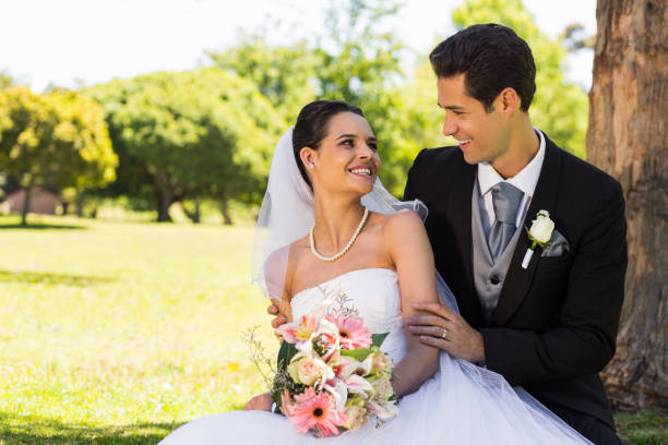 istock Happy newlywed couple sitting in park 843752036