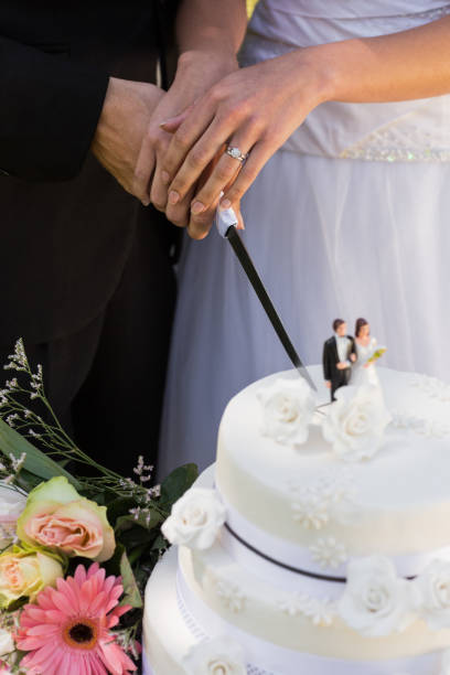 istock Mid section of newlywed cutting wedding cake 843752460