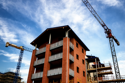 Building construction work yard with crane and clouds