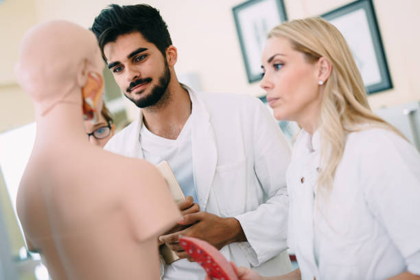 istock Students of medicine examining anatomical model in classroom 843763358