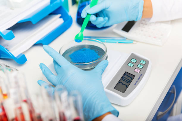 Scientist in gloves preparing chemical substances for the tests Scientist in gloves measuring weight of blue bulk solid substance in the scientific chemical laboratory laboratory shaker stock pictures, royalty-free photos & images