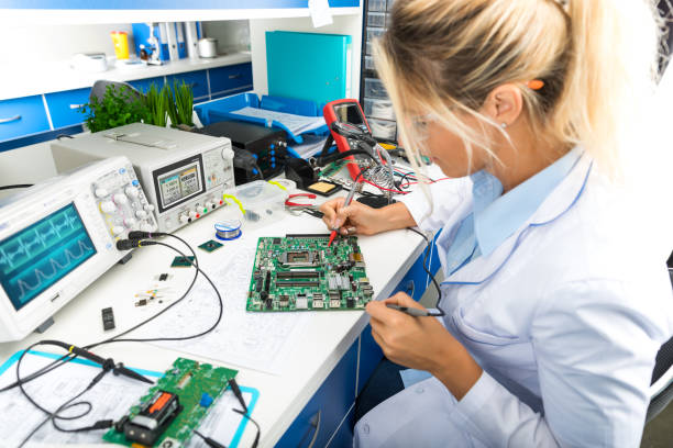 Female electronic engineer testing computer motherboard in laboratory Young female digital electronic engineer testing computer PC motherboard in laboratory electronics stock pictures, royalty-free photos & images