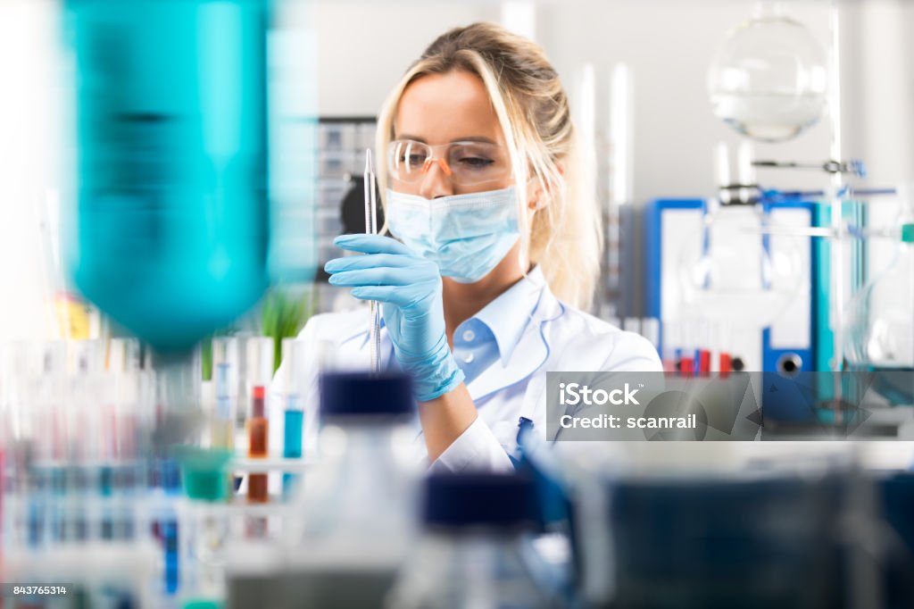 Giovane scienziata attraente che prepara attrezzature di laboratorio per i test - Foto stock royalty-free di Farmaco