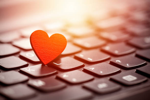 Small red heart on keyboard. Internet dating concept. stock photo