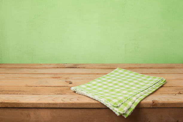 istock Empty wooden deck table with checked tablecloth over green wall background for product montage display 843774904