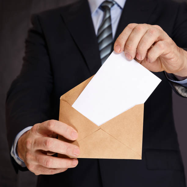 istock A man puts a white sheet of paper in an envelope 843781804