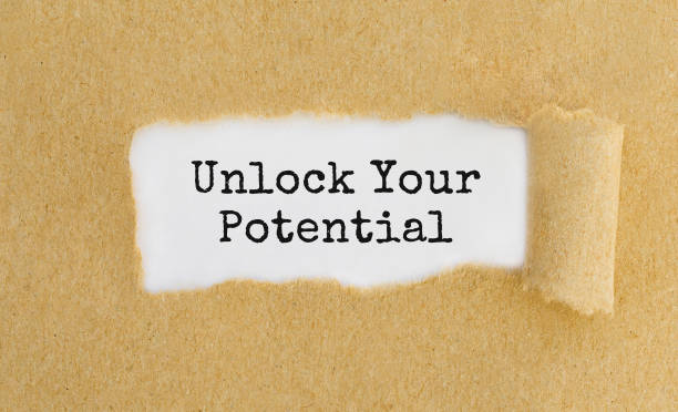 istock Text Unlock Your Potential appearing behind ripped brown paper. 843785426