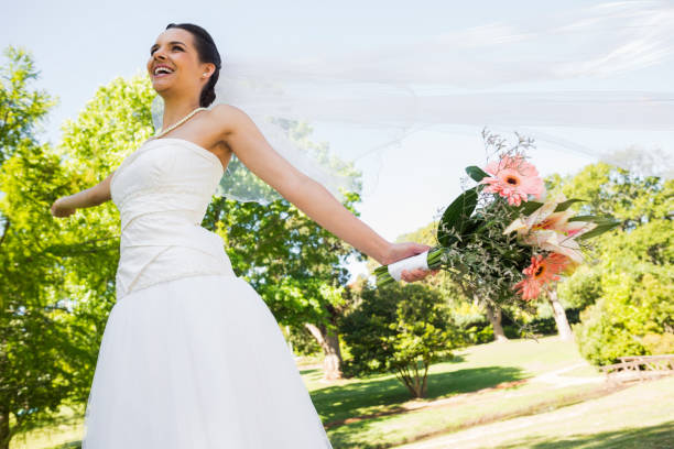istock Cheerful young beautiful bride with bouquet in park 843786150