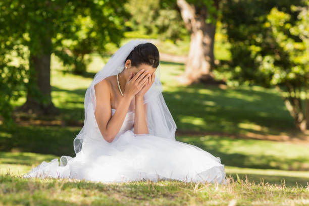 piękna zaniepokojona panna młoda siedząca w parku - bride veil women human face zdjęcia i obrazy z banku zdjęć