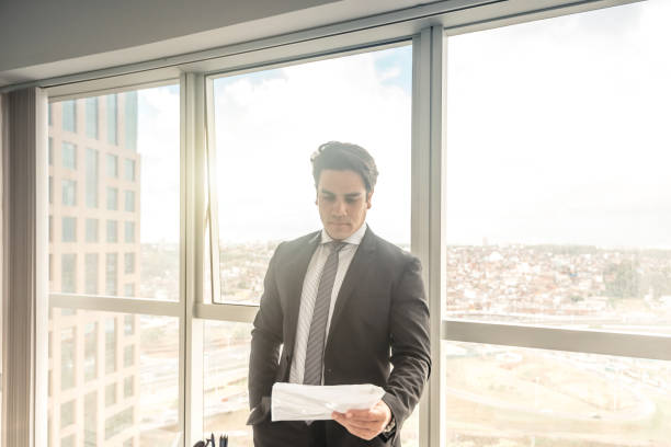istock handsome brazilian businessman reading contract 843789988
