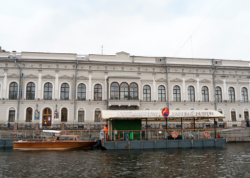 A man standing on a pontoon landing stage outside the Fabergé Museum situated in the Shuvalov Palace beside the Fontanka River in St Petersburg, Russia, on an overcast day. The world’s largest collection of pieces by the jeweller Carl Fabergé is contained wihtn the museum, which was opened in 2013.