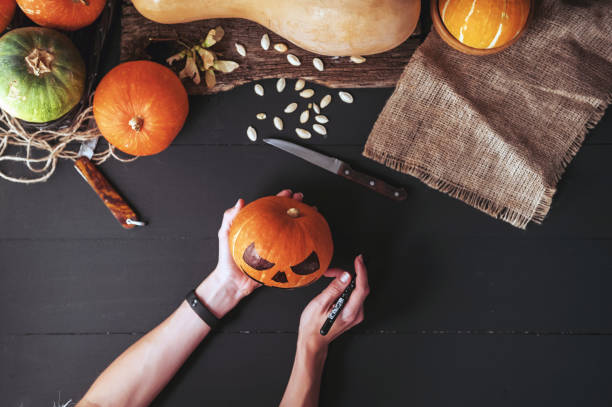 woman decorates a pumpkin to celebrate halloween