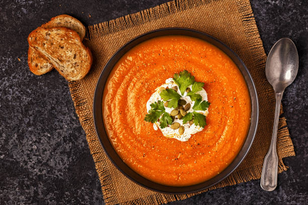 istock Pumpkin and carrot soup with cream, seeds and parsley. 843806784