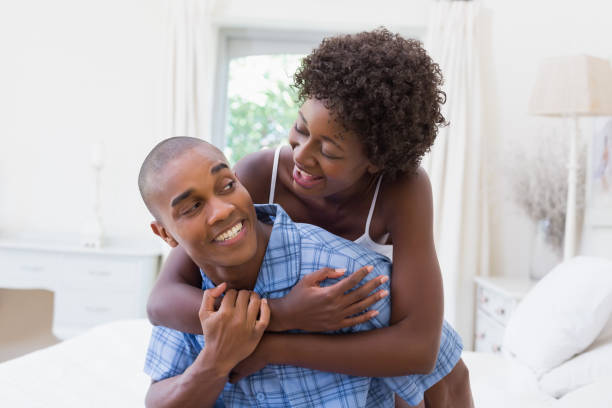 istock Happy couple messing about on their bed 843817648